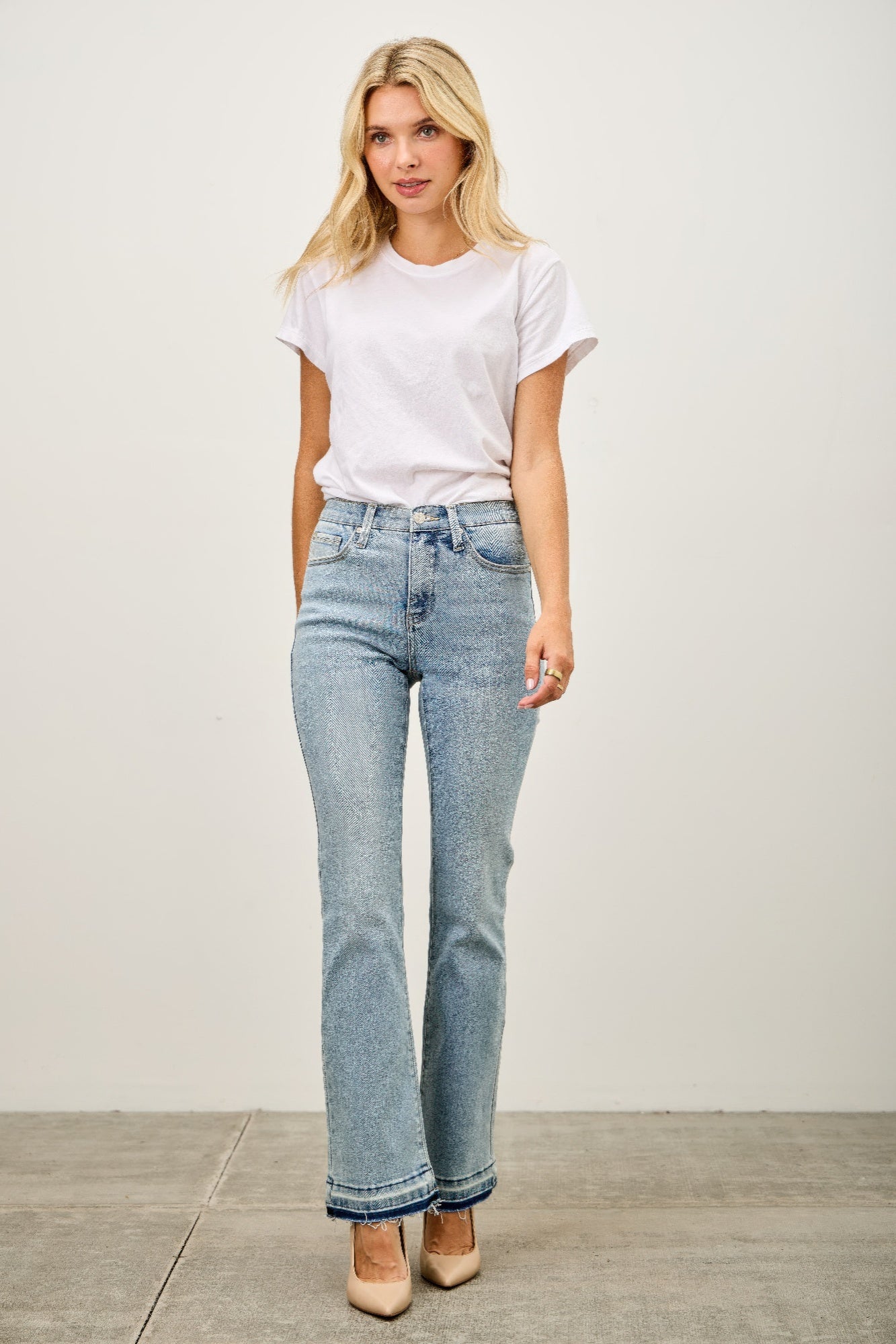 Toshe Women's Fashions mid-rise flare jeans with released hem, shown on a model, featuring a stylish and casual denim look.