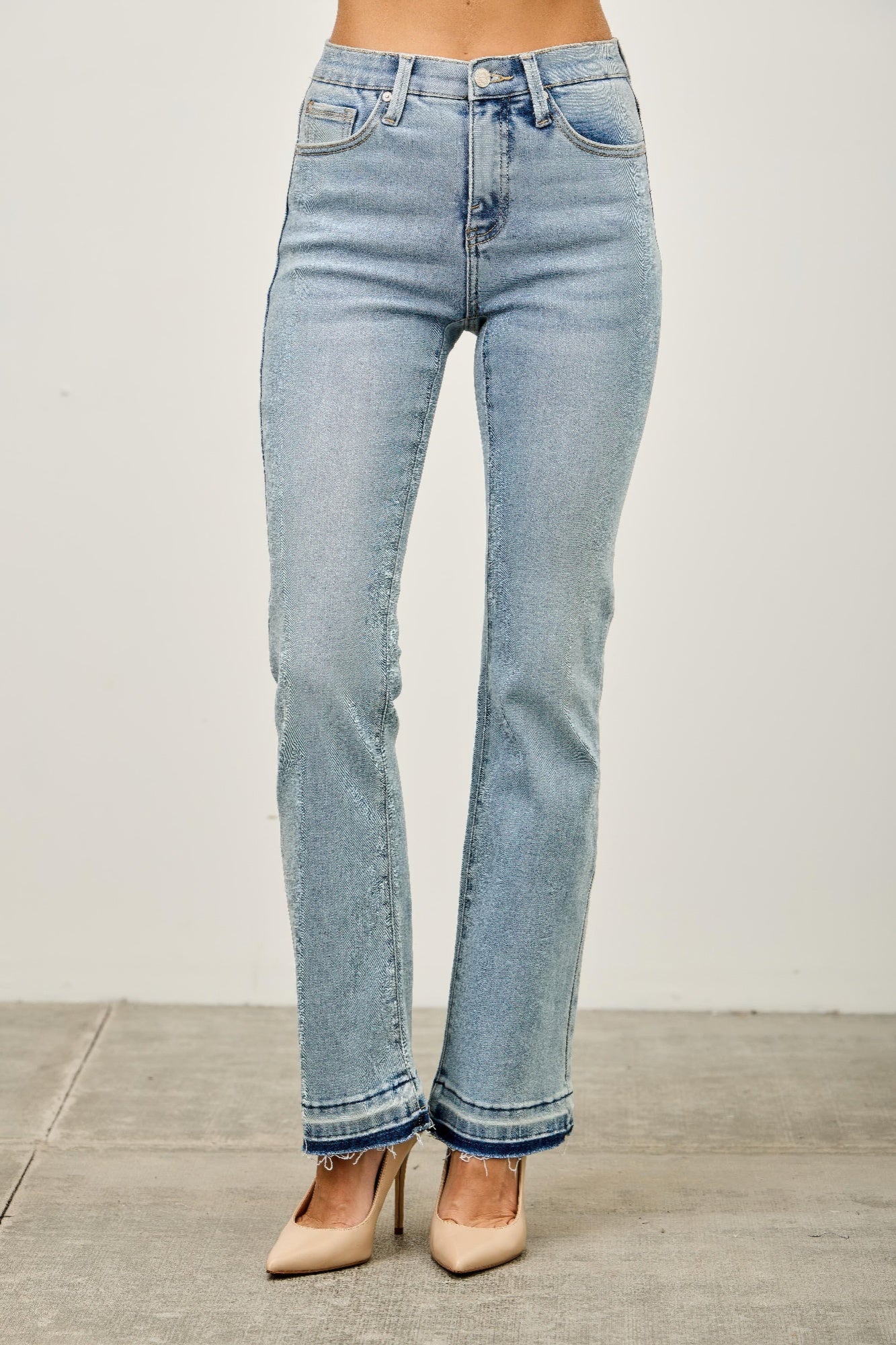 Toshe Women's Fashions mid-rise flare jeans with released hem, shown on a model, featuring a stylish, relaxed fit.