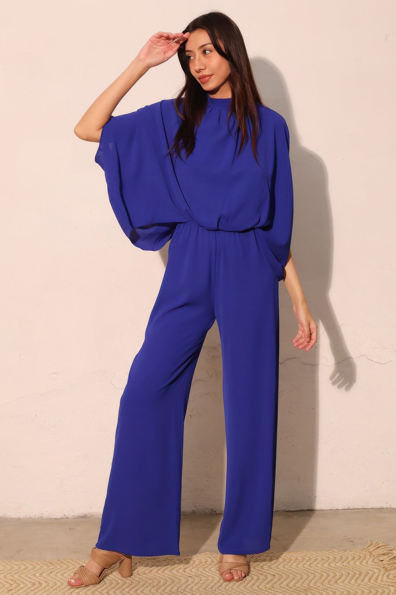 Textured solid mock neck caftan jumpsuit by Toshe Women's Fashions, displayed in a relaxed fit with wide legs and long sleeves.