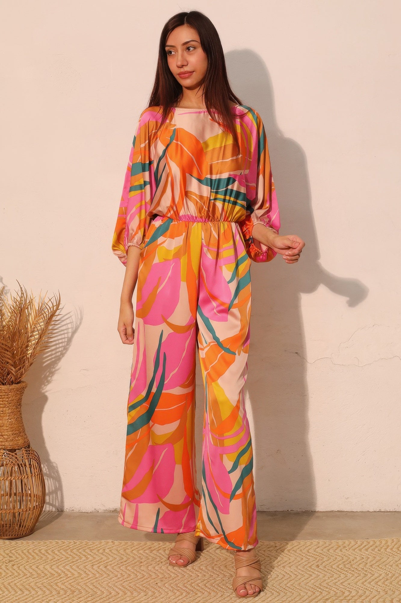 Toshe Women's Fashions Isla Tropical Satin Boat Neck Blouson Jumpsuit displayed on a model, featuring a relaxed fit and tropical print.