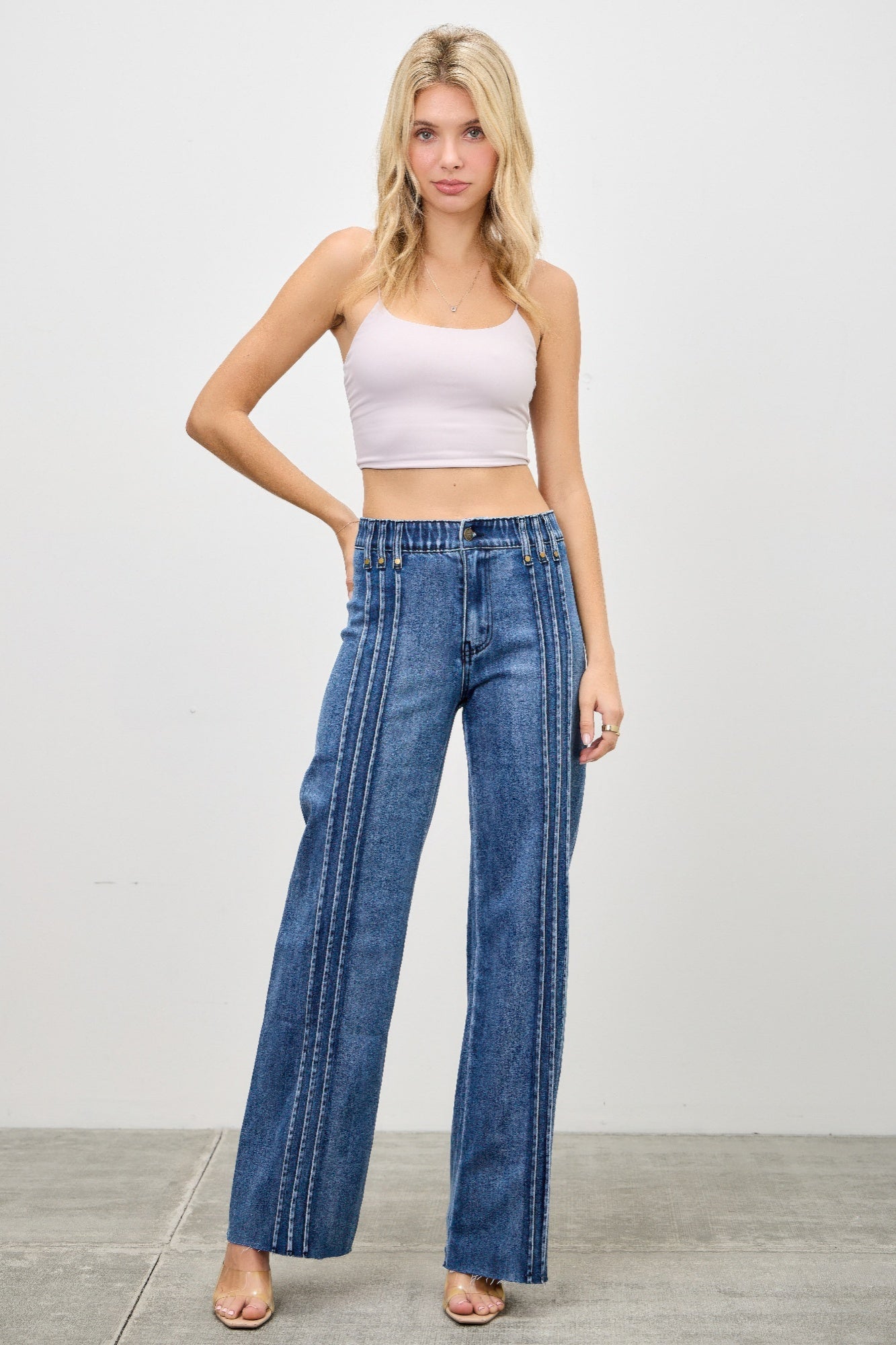 Toshe Women's Fashions high rise straight jeans with front line detailing, shown on a model, in a light denim wash.