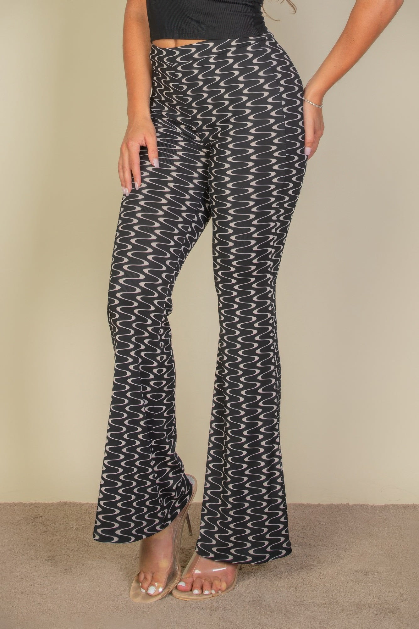 Wavy print high waist flare pants by Toshe Women's Fashions, showcased on a model, featuring a vibrant wave pattern and wide-leg design.