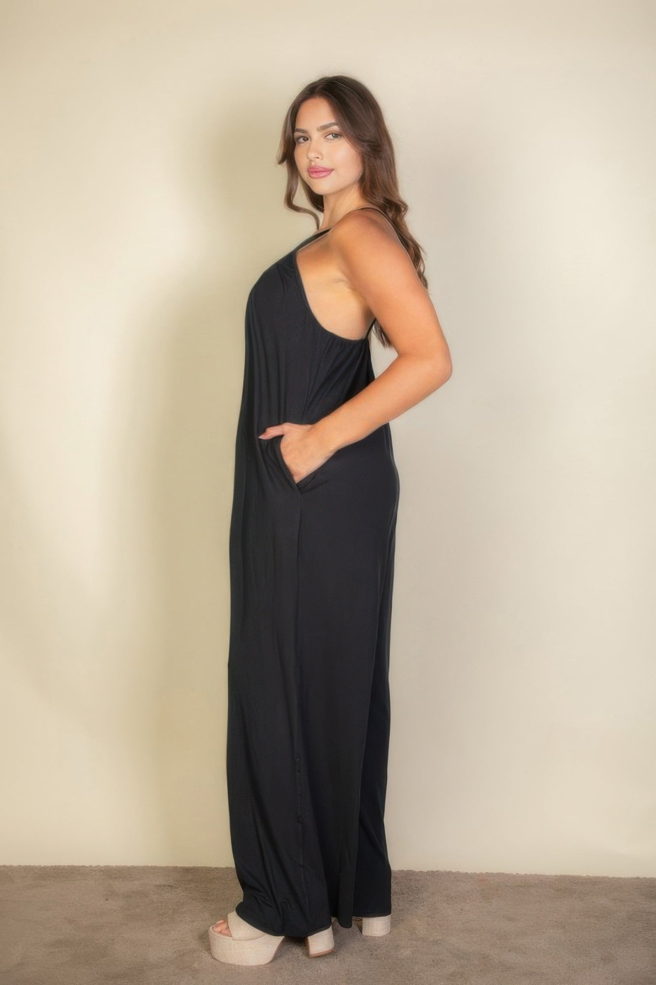 Toshe Women's Fashions spaghetti strap solid wide-leg jumpsuit hanging on a hanger, showing its relaxed fit and stylish design.