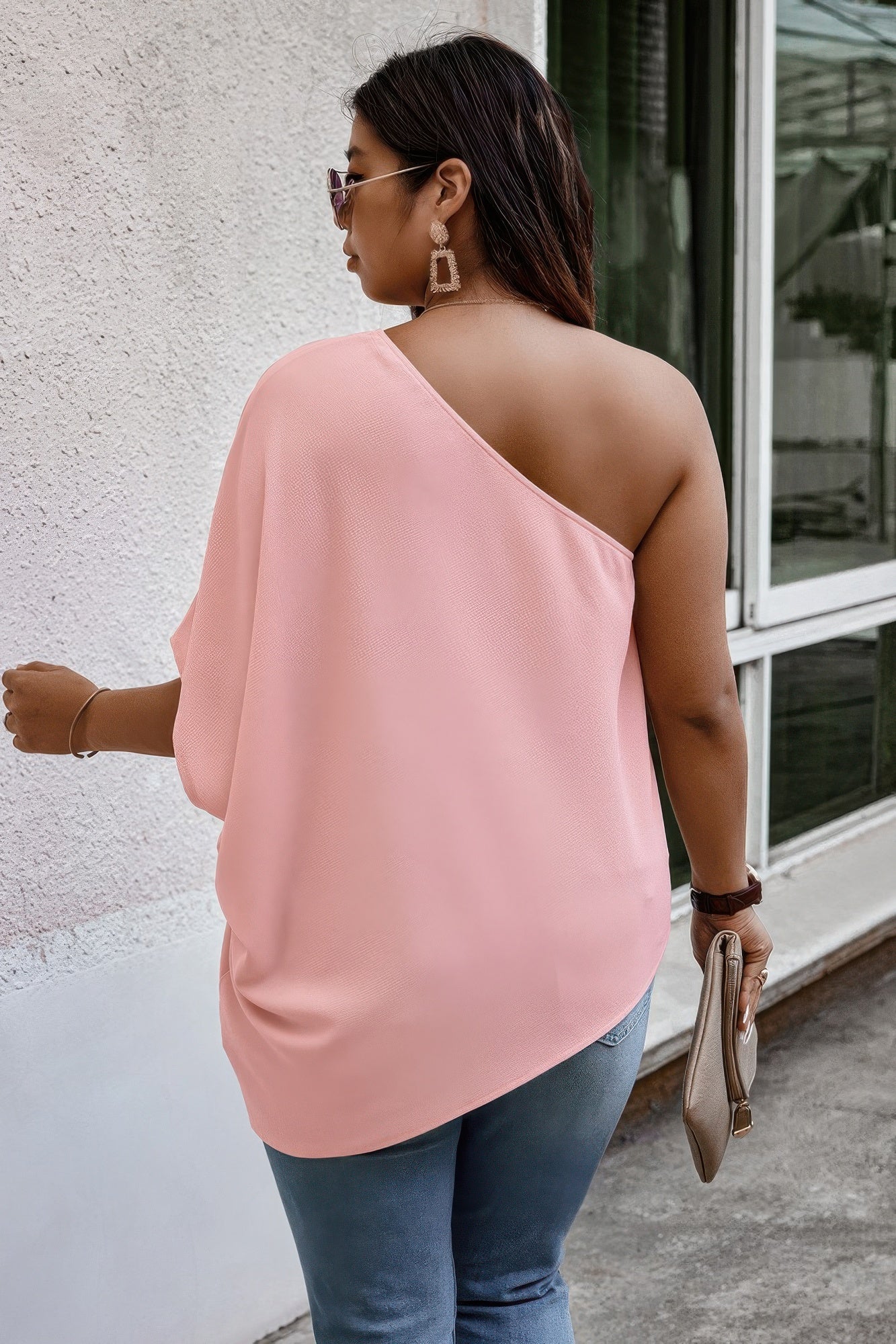 Light beige one-shoulder loose fit shirt from Toshe Women's Fashions, displayed on a hanger with a soft fabric texture.