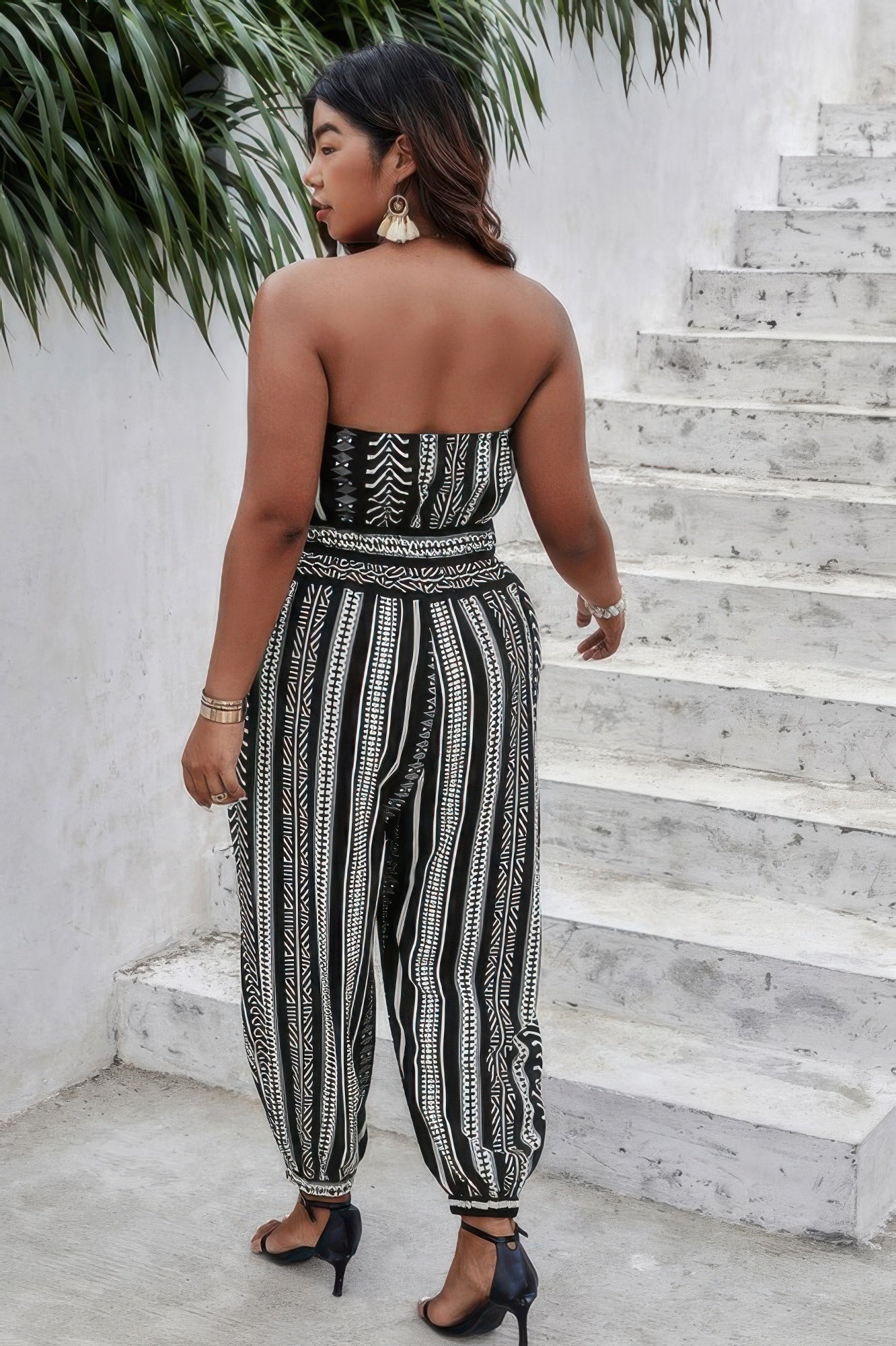 Black and white off-shoulder sleeveless jumpsuit by Toshe Women's Fashions, displayed on a hanger.