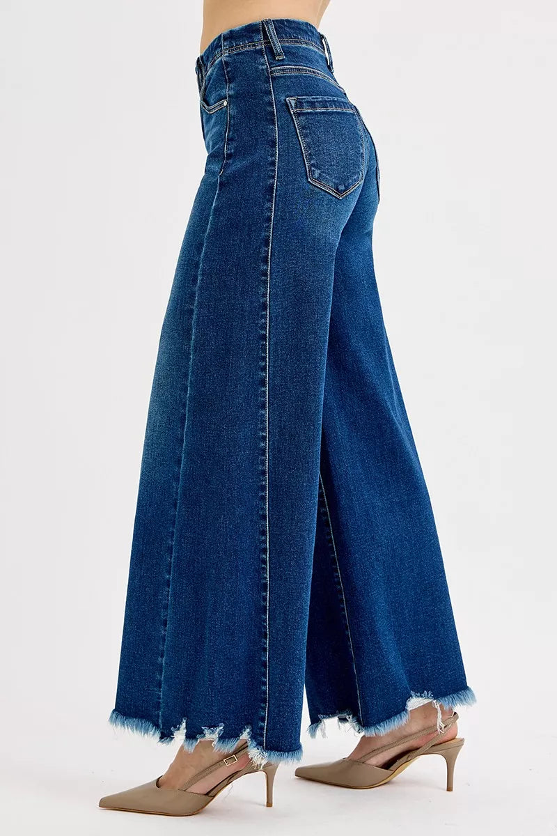 Frayed hem high-rise ankle wide jeans in denim with a trendy distressed finish, stylishly displayed on a model.