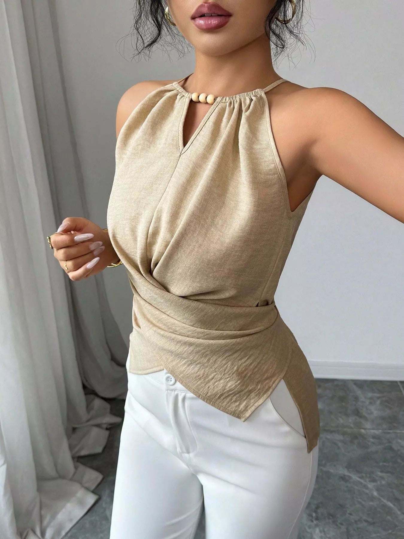 Halter neck crisscross cami top by Trendsi, featuring a stylish design with thin straps and a fitted silhouette.