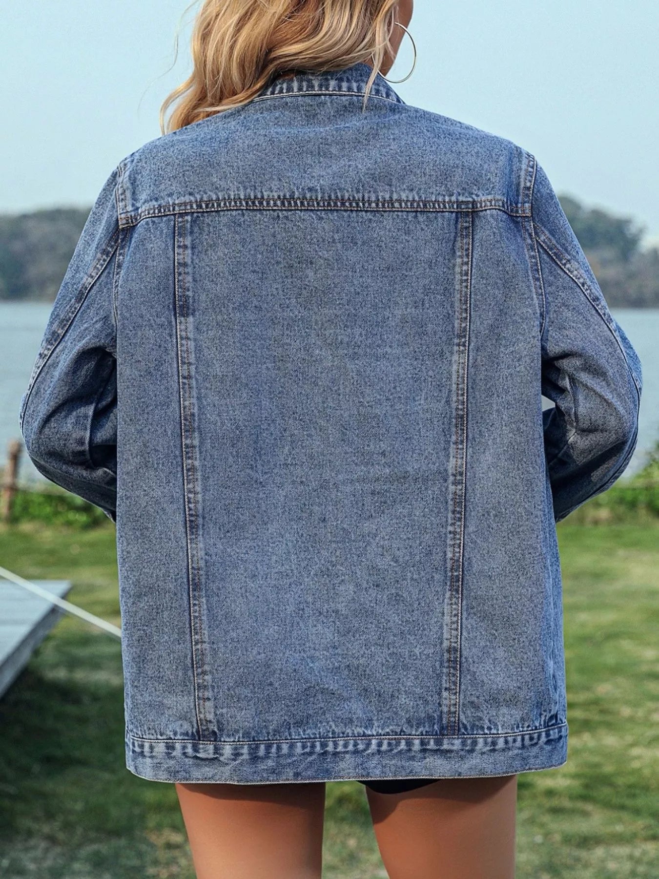 Studded button-up denim jacket from Trendsi with metal studs, classic collar, and long sleeves, displayed on a plain background.
