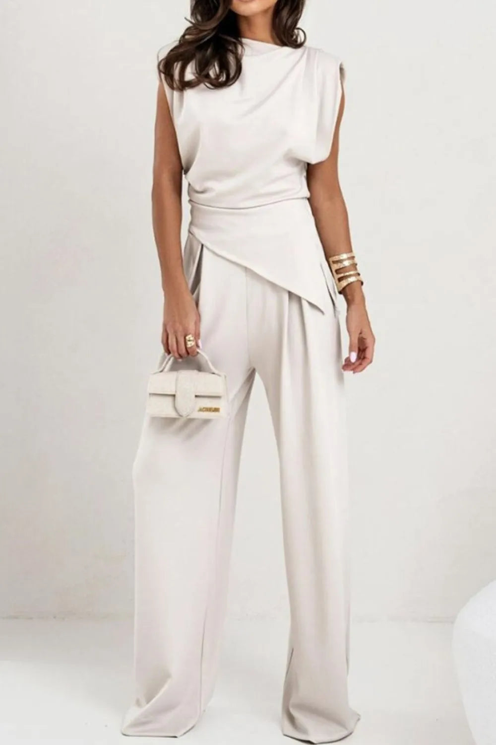 Draped sleeveless asymmetric top and matching pants set by Trendsi, featuring stylish drape details and modern silhouette.