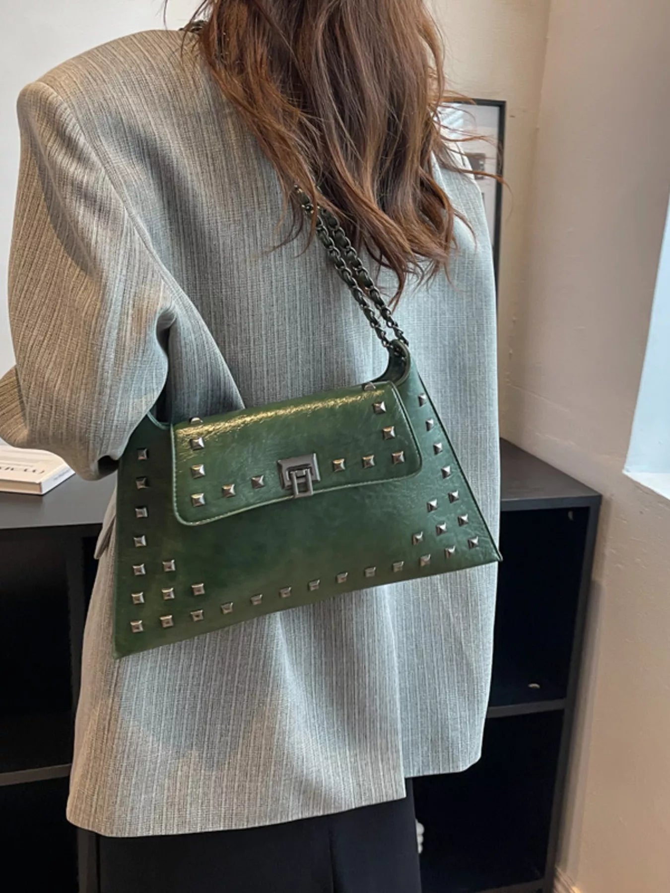 Black studded flap chain shoulder bag with silver hardware, trendy handbag featuring a chain strap and textured surface.
