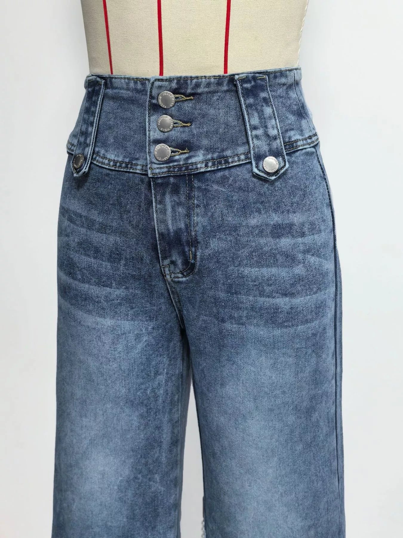 High waist denim wide leg jeans with button decor from Trendsi, displayed on a hanger against a white background.