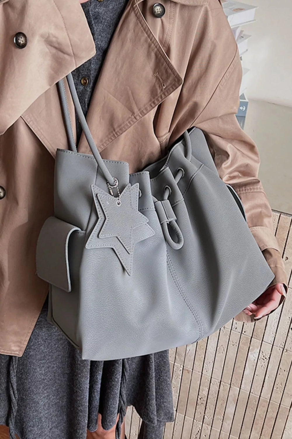 Drawstring shoulder bag by Trendsi featuring a star charm, with a sleek design and adjustable strap, ideal for casual or stylish use.