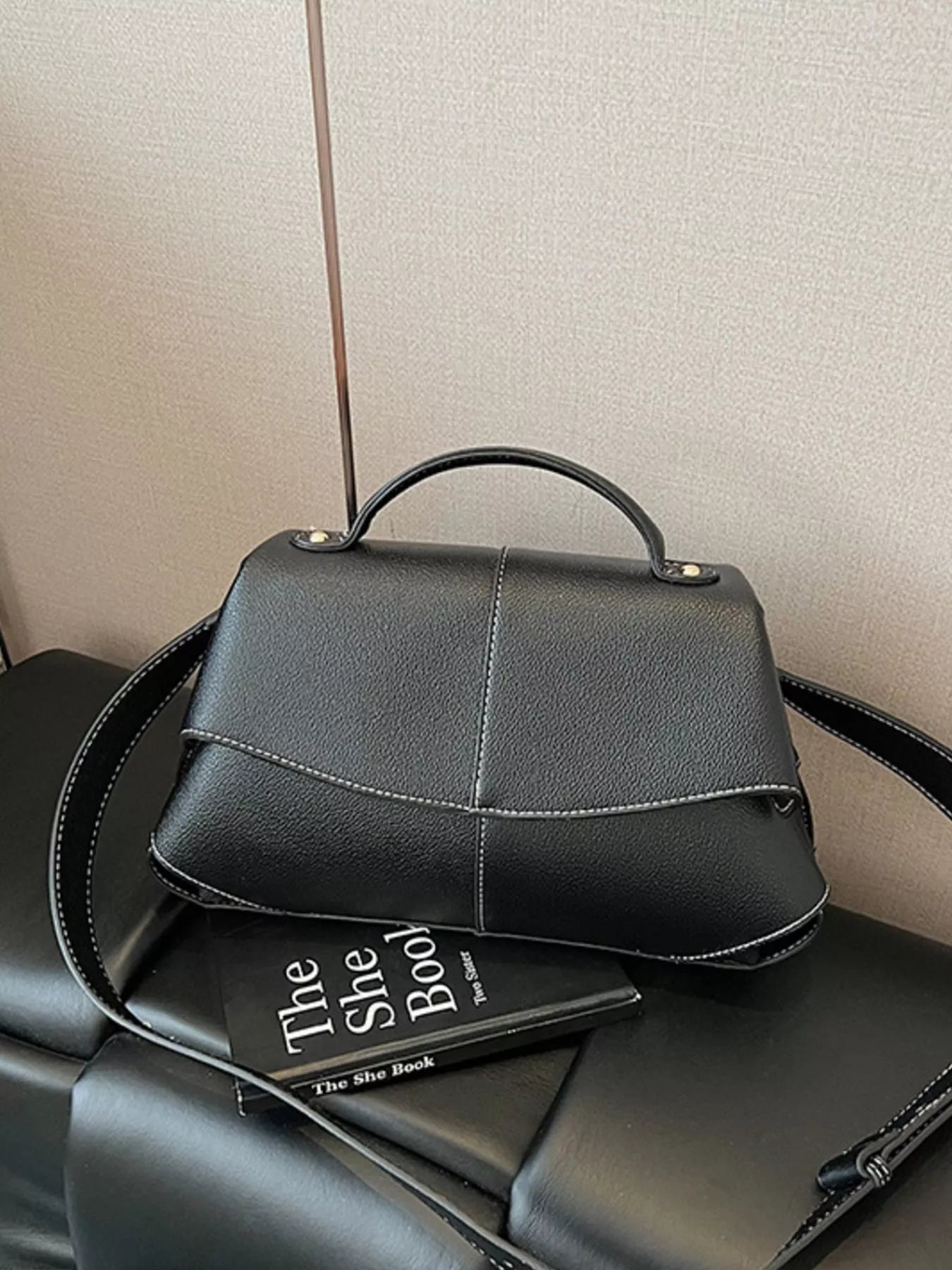 Geometric flap shoulder bag by Trendsi, stylish handbag with angular design, top handle, and shoulder strap for versatile wear.