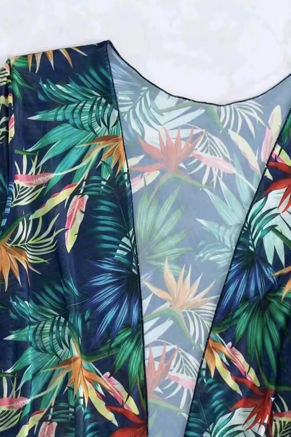 Printed halter neck three-piece swimwear set from Trendsi, featuring a colorful bikini top, matching bottom, and cover-up.