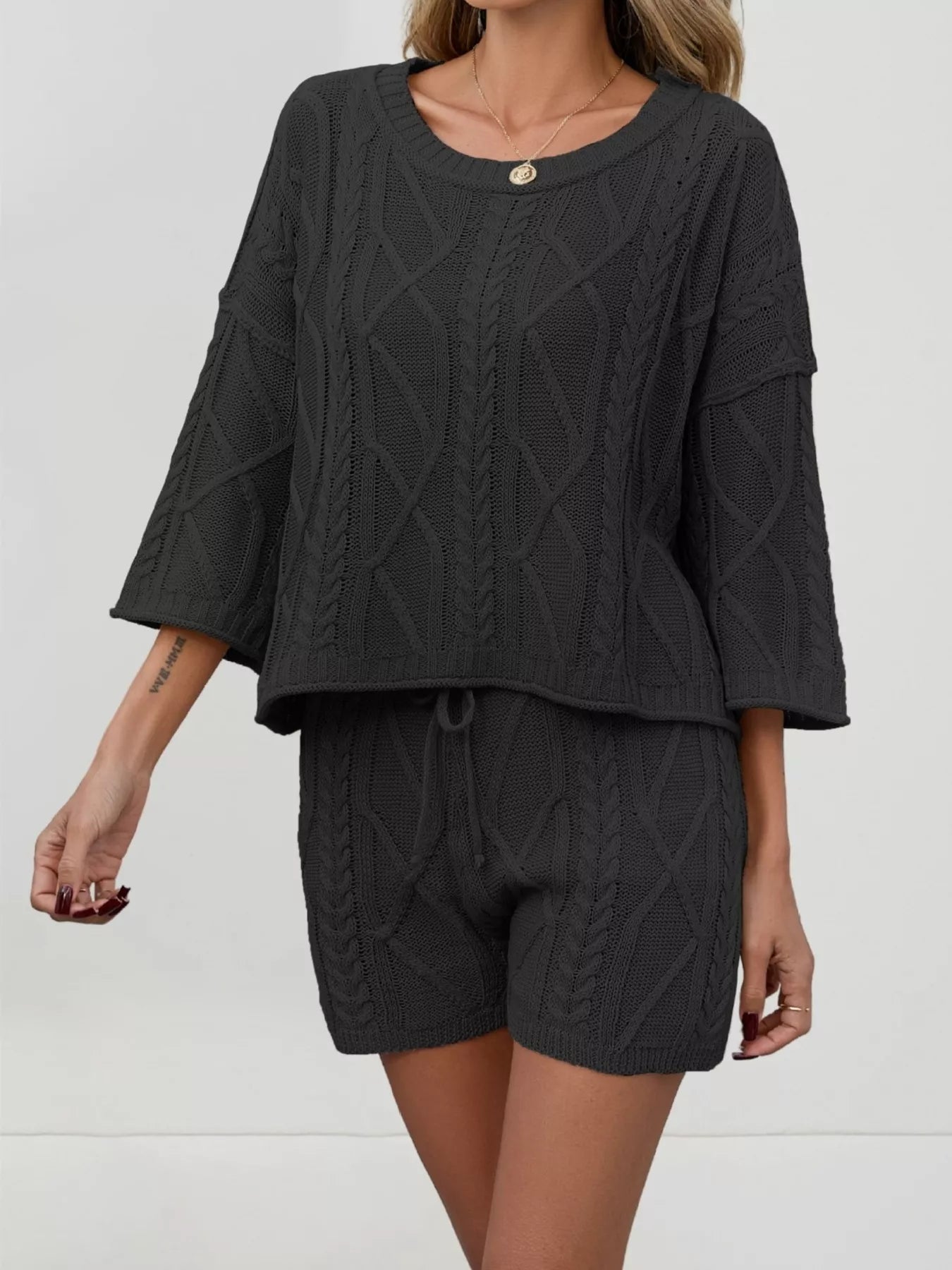Cable knit round neck top and shorts sweater set by Trendsi, featuring a cozy knit fabric and classic design.