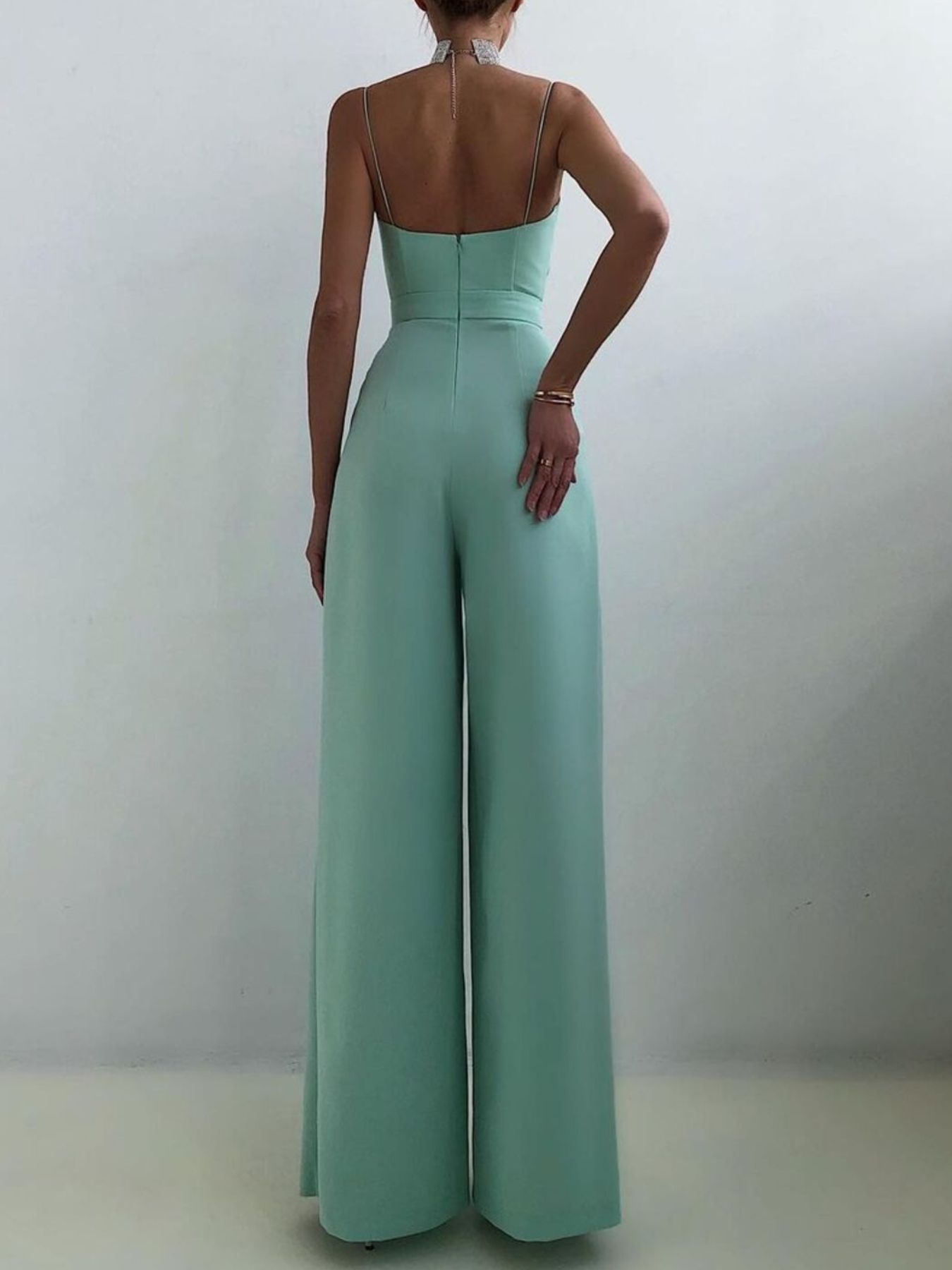 Light beige spaghetti strap wide-leg jumpsuit from Trendsi, featuring a fitted bodice and flowing pant legs.