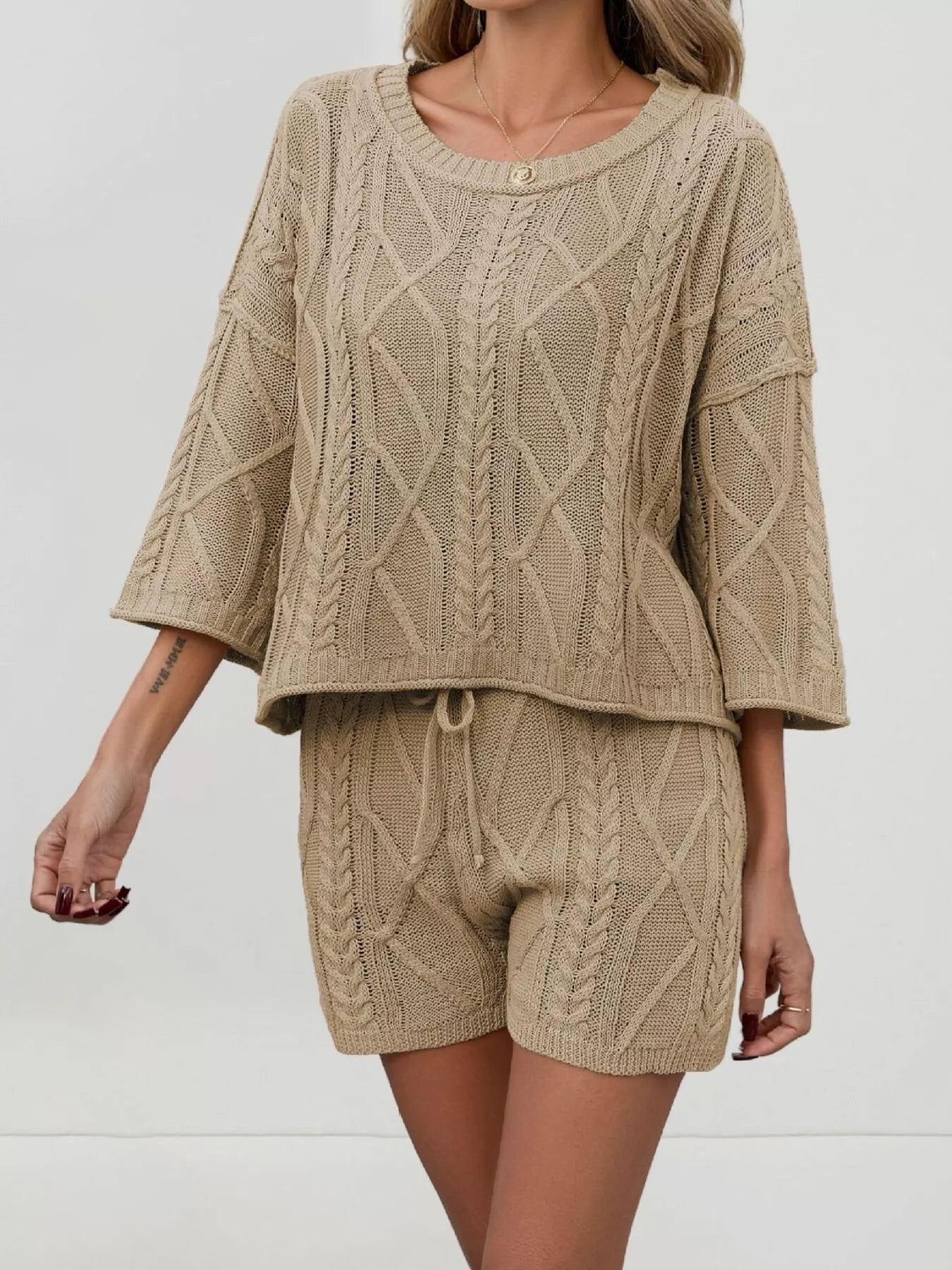 Cable knit round neck top and shorts sweater set by Trendsi, featuring a cozy knit texture and stylish matching design.