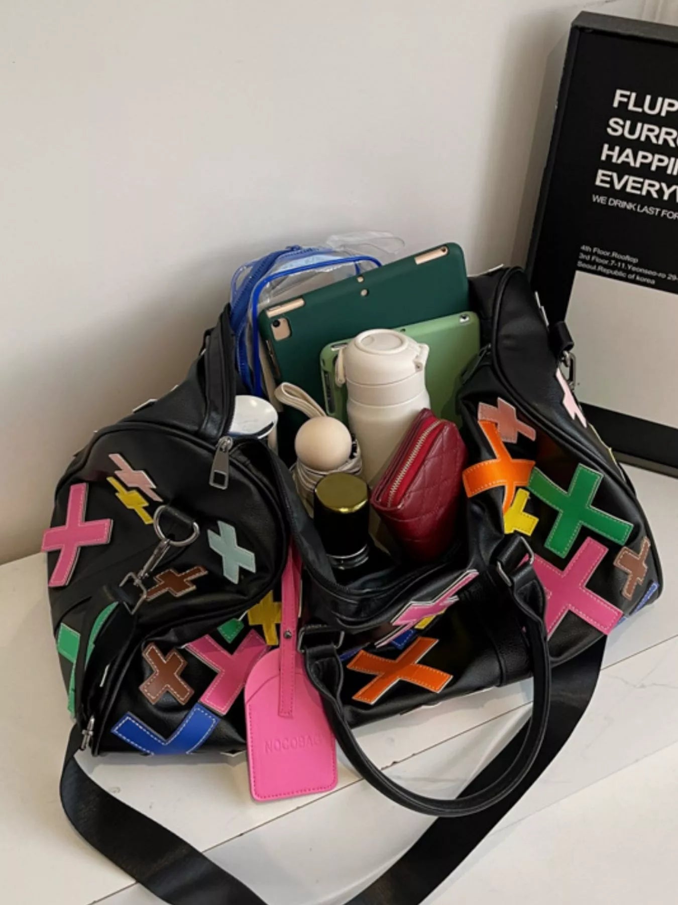 Colorful cross pattern travel duffel bag from Trendsi, showing spacious design and vibrant textile with sturdy handles.