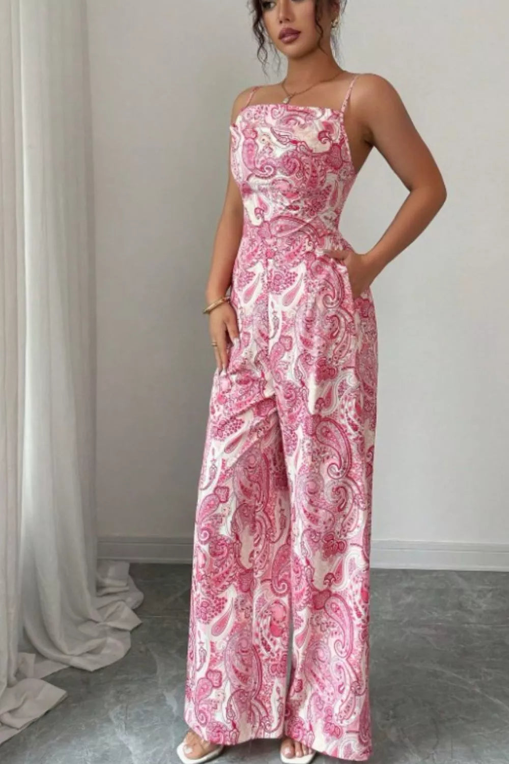 Pink paisley wide leg jumpsuit from Trendsi, featuring a flowy fit and stylish pattern, displayed on a hanger against a white background.