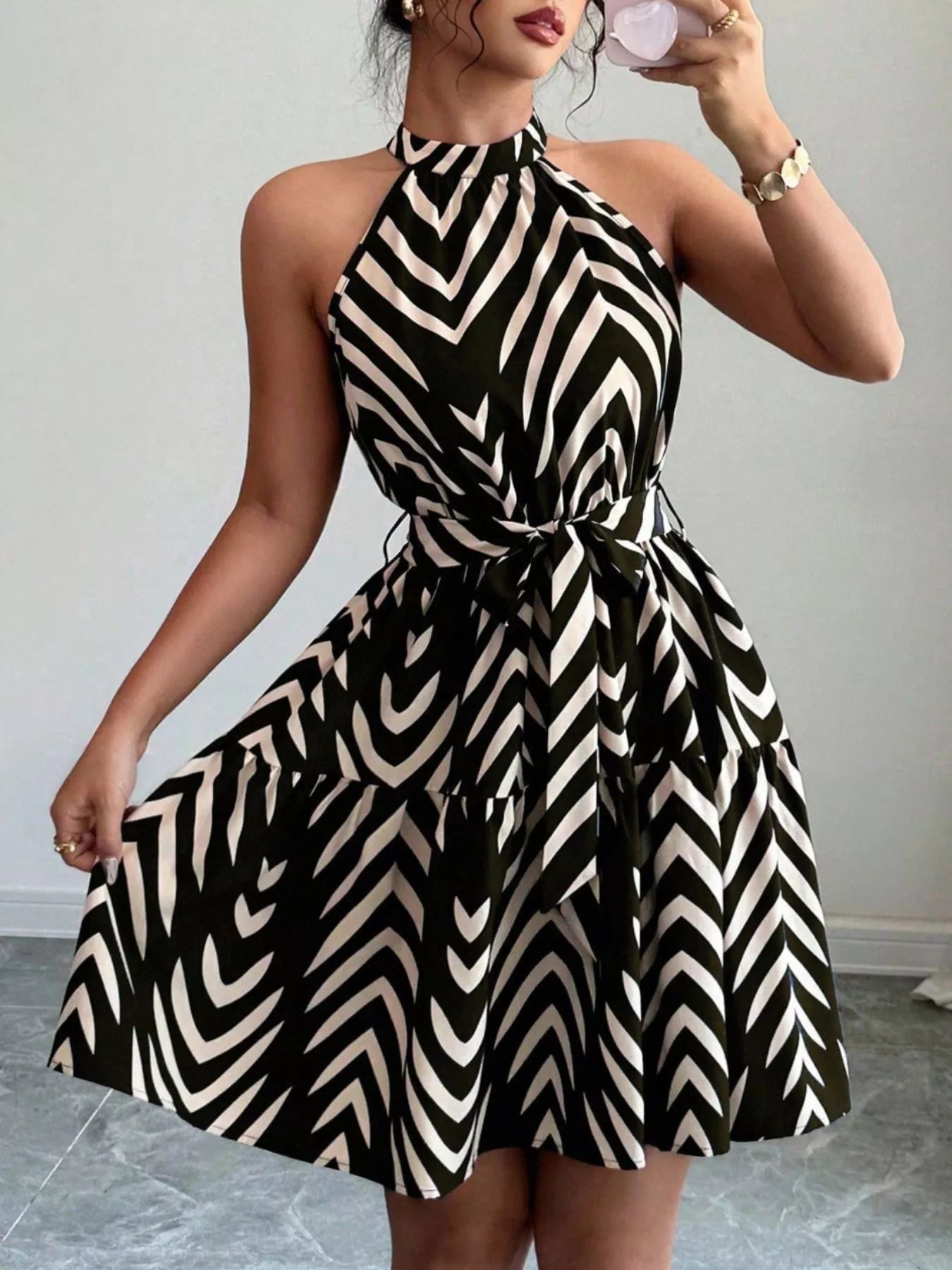 Zebra print halter neck dress with tie waist and ruffle hem, trendy women's dress by Trendsi, perfect for stylish summer wear.