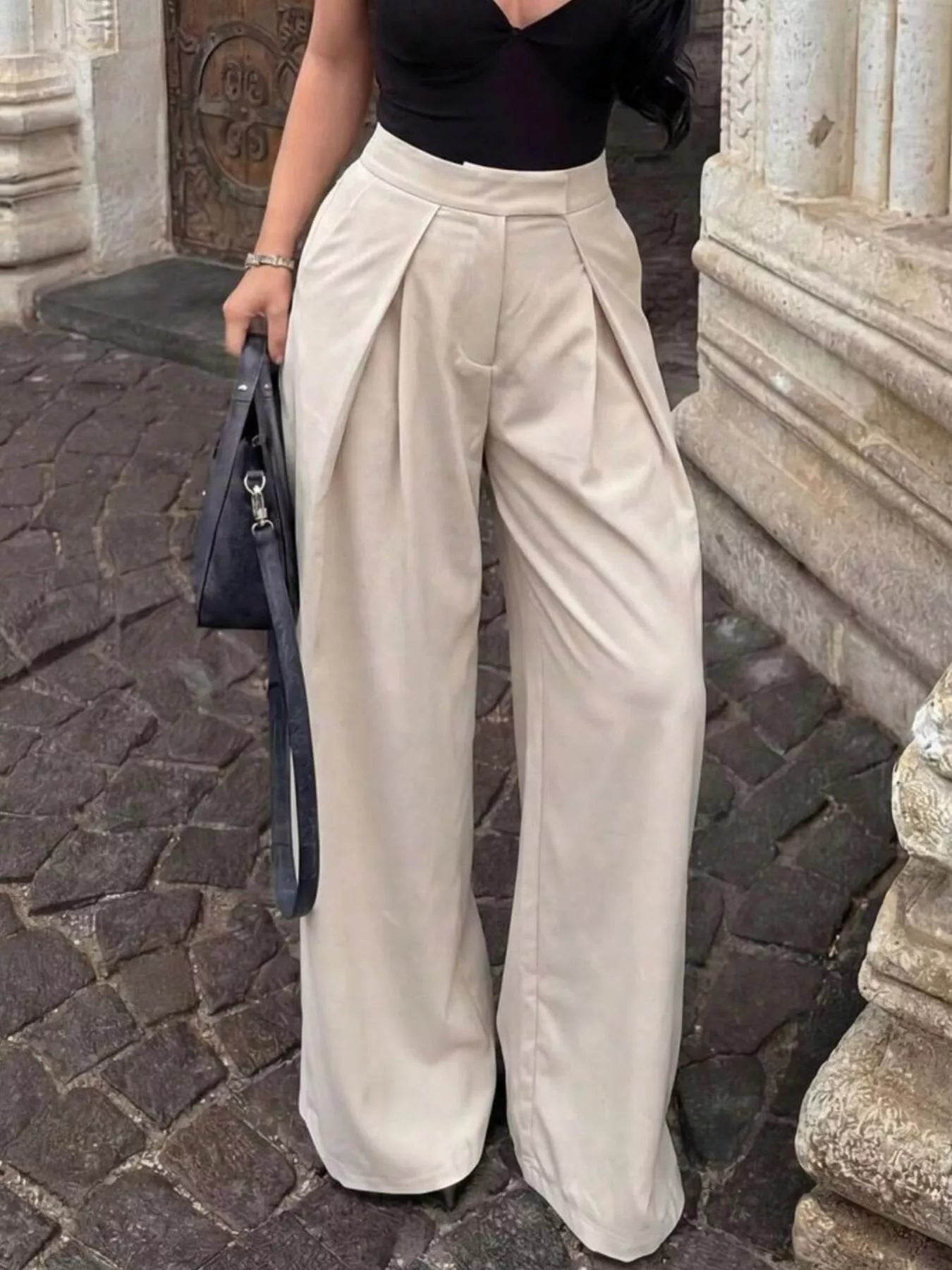 High-waisted pleated wide-leg trousers by Trendsi, featuring flowing fabric and stylish design, shown on a neutral background.