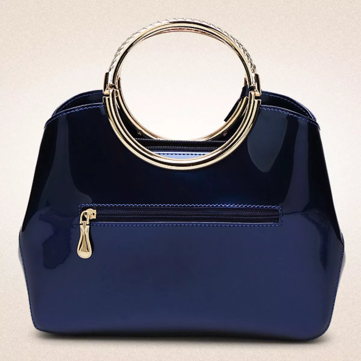 Glossy gold ring handle handbag with sleek design, featuring a shiny gold hardware detail, ideal for stylish everyday use.