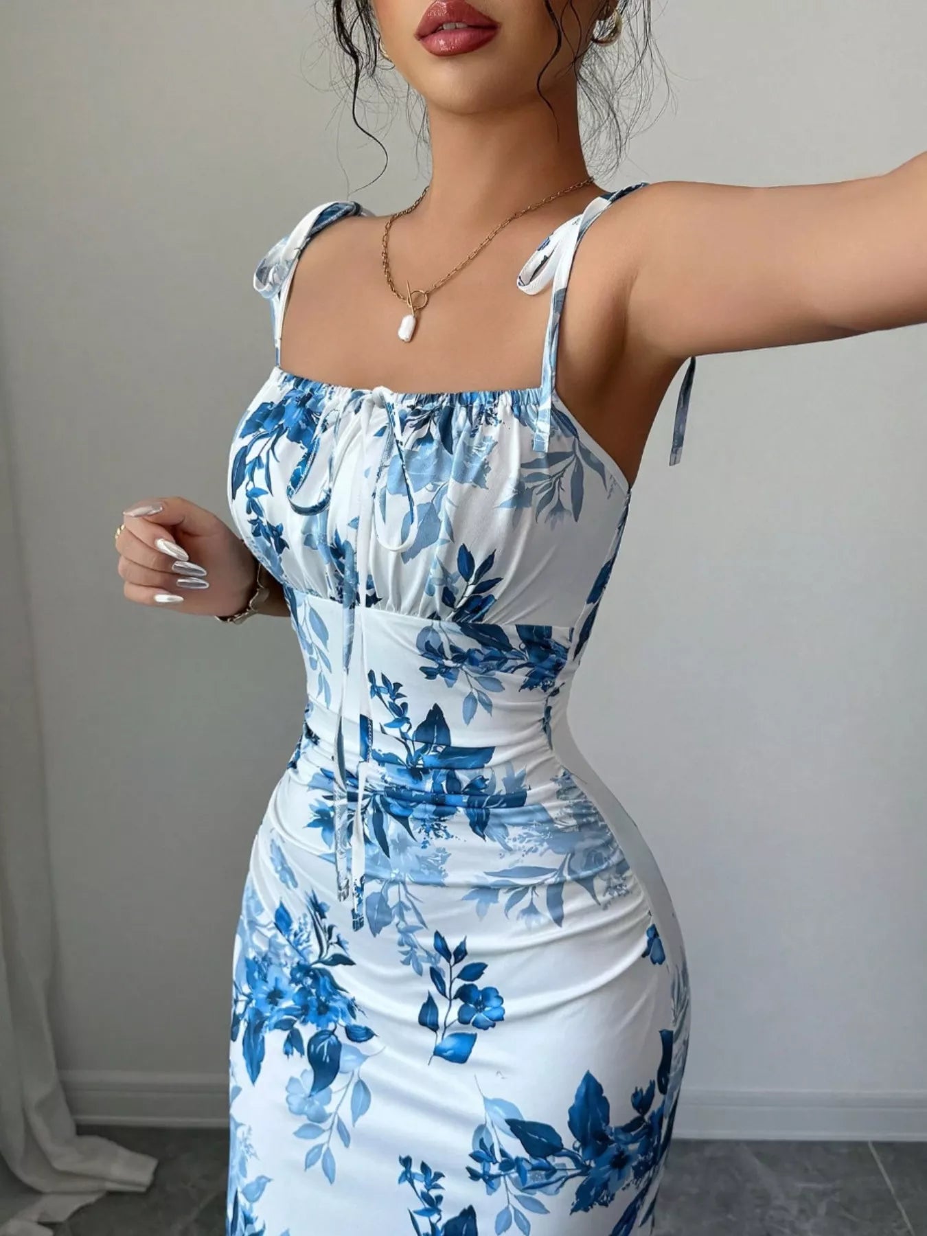 Printed tie strap slit maxi dress by Trendsi featuring a flowing silhouette, adjustable straps, and a stylish slit design.