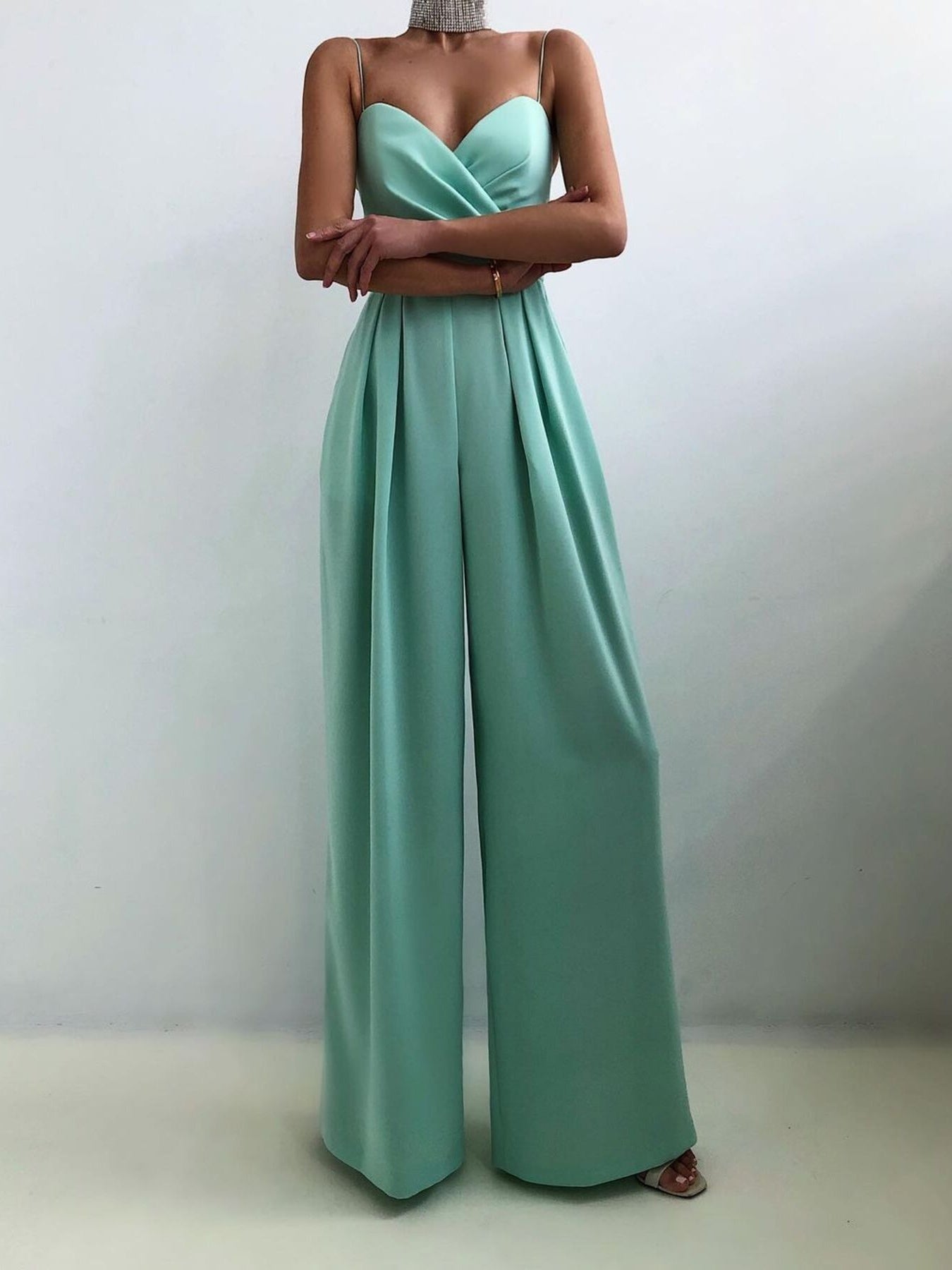 Trendsi spaghetti strap wide-leg jumpsuit displayed on a hanger, featuring a fitted bodice and flowing wide-leg pants.