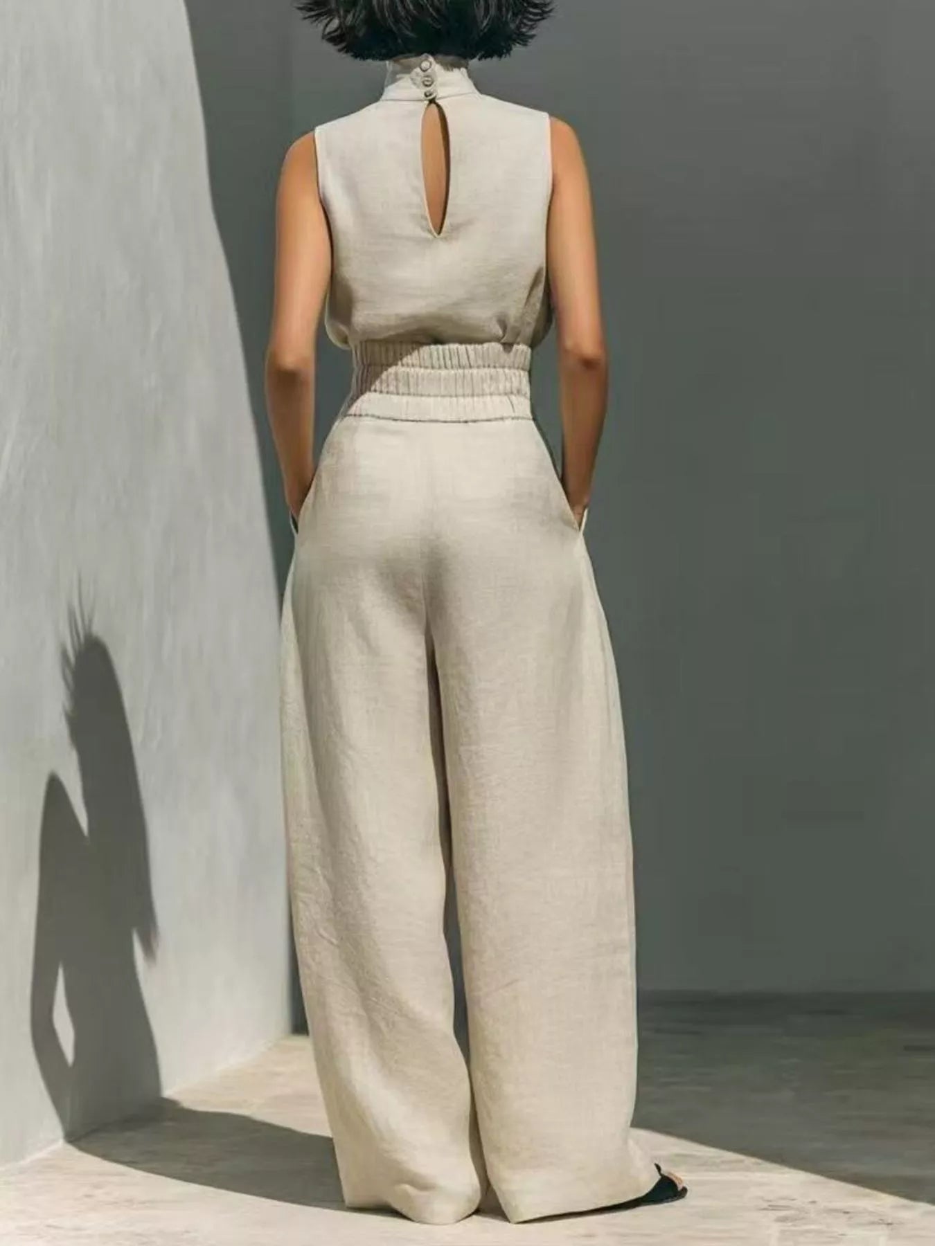 Trendsi high neck sleeveless top and wide-leg pants set in light fabric, displayed on a hanger against a neutral background.